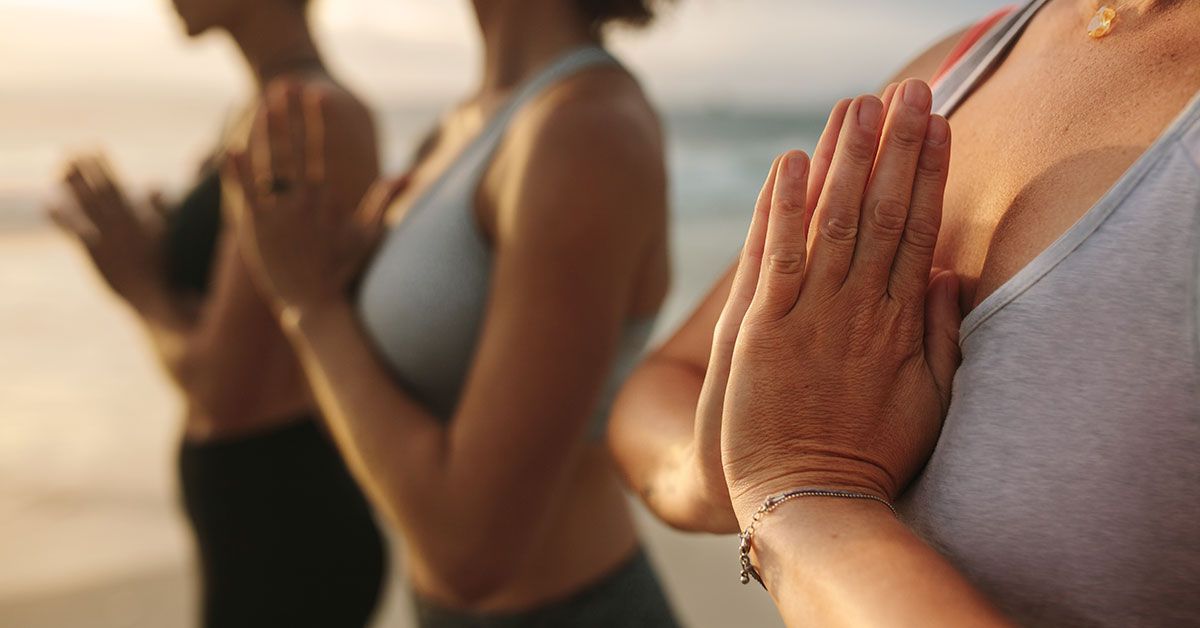 A group of women practicing yoga during their wellness vacation in Ibiza.